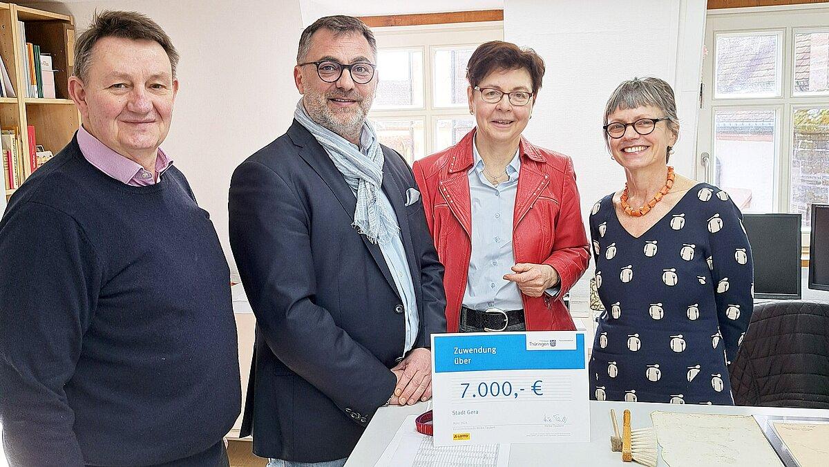 Holger Saupe (Leiter der Kunstsammlung Gera, li.), Oberbürgermeister Julian Vonarb (2.v.l.) und Papierrestauratorin Franziska Pucher (r.) nehmen die Lottomittel von Finanzministerin Heike Taubert (2.v.r.) entgegen