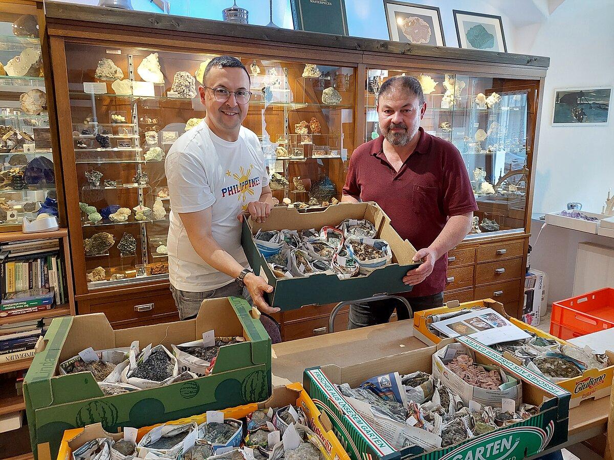 Frank Hrouda (li.) übergibt zahlreiche Kisten mit zerfallsgefährdeten Mineralien aus der Sammlung des Museums für Naturkunde Gera an Tilo Pönitz (re.) in Freiberg