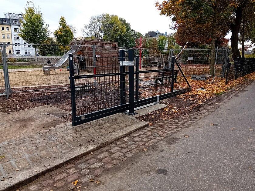 Ein neues Rolltor samt Zaun vor einem Spielplatz in Piratenschiff-Form. © Stadt Gera