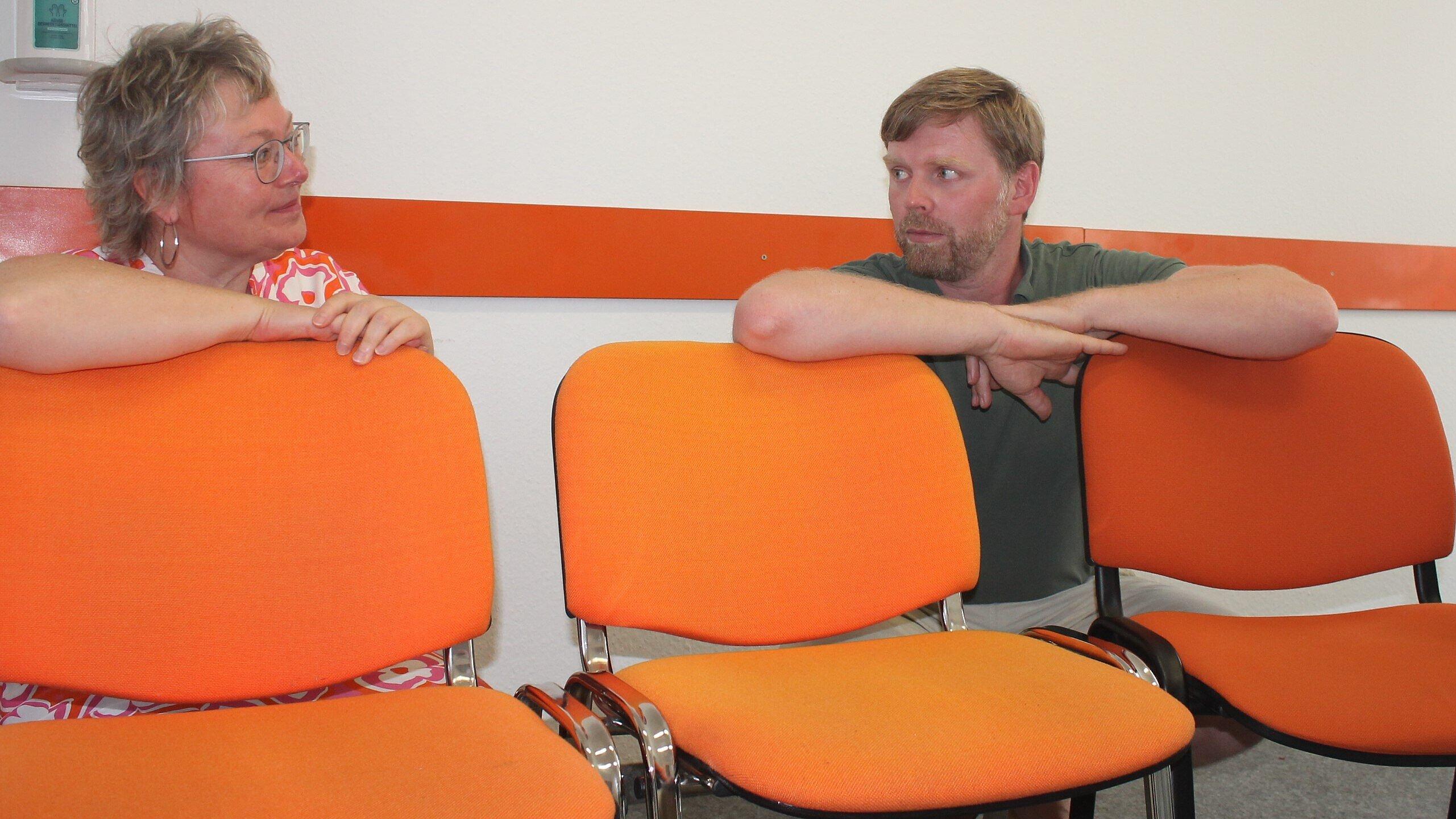 Platz nehmen auf den orangen Stühlen im Projekt Orange in Gera bei André Schneider (r.) können hier Personen, die Gewalt ausüben oder die einschätzen, gewalttätig werden zu können. Das Projekt Orange begleitet professionell und über einen längeren Zeitraum. Darauf möchte die Geraer Gleichstellungsbeauftragte Catrin Heinrich (r.) mit ihren Besuchen bei Mitgliedern des Netzwerkes gegen häusliche Gewalt aufmerksam machen. . © Stadt Gera / Miriam Vinzelberg