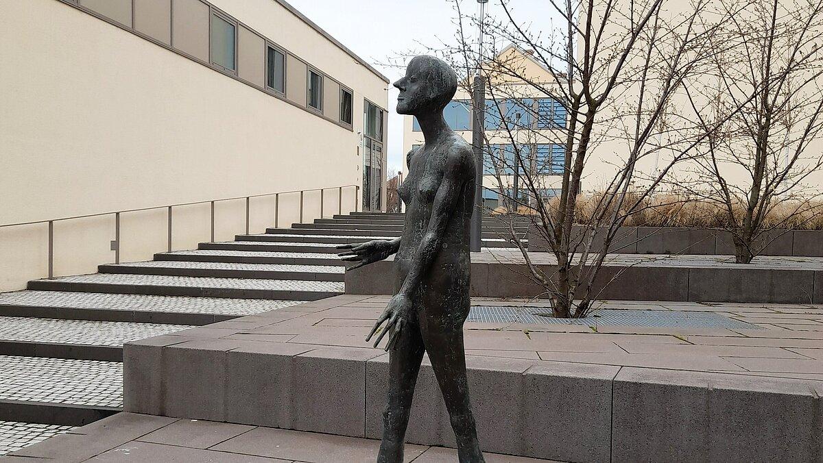 Eine lebensgroße Bronzeskulptur mit dem Namen "Schreitende" steht in der Fußgängerzone. © Stadt Gera