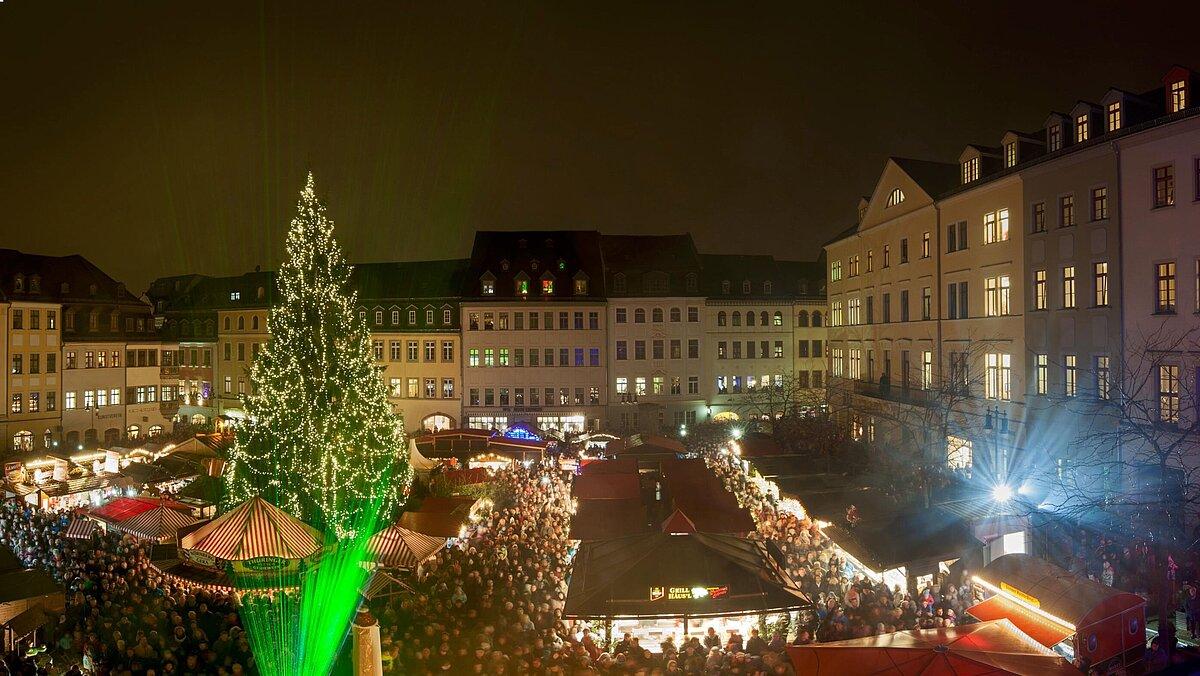 Blick auf den Marktplatz Gera am Abend, Weihnachtsbaum in der Mitte, viele Menschen an den Ständen. © Stadt Gera