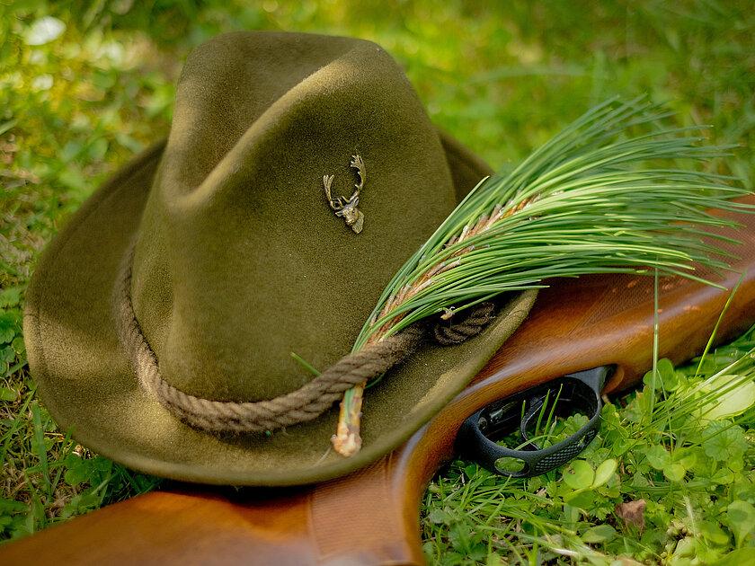 Ein Jägerhut und ein Gewehr, die auf Moos liegen. © Lukas - stock.adobe.com