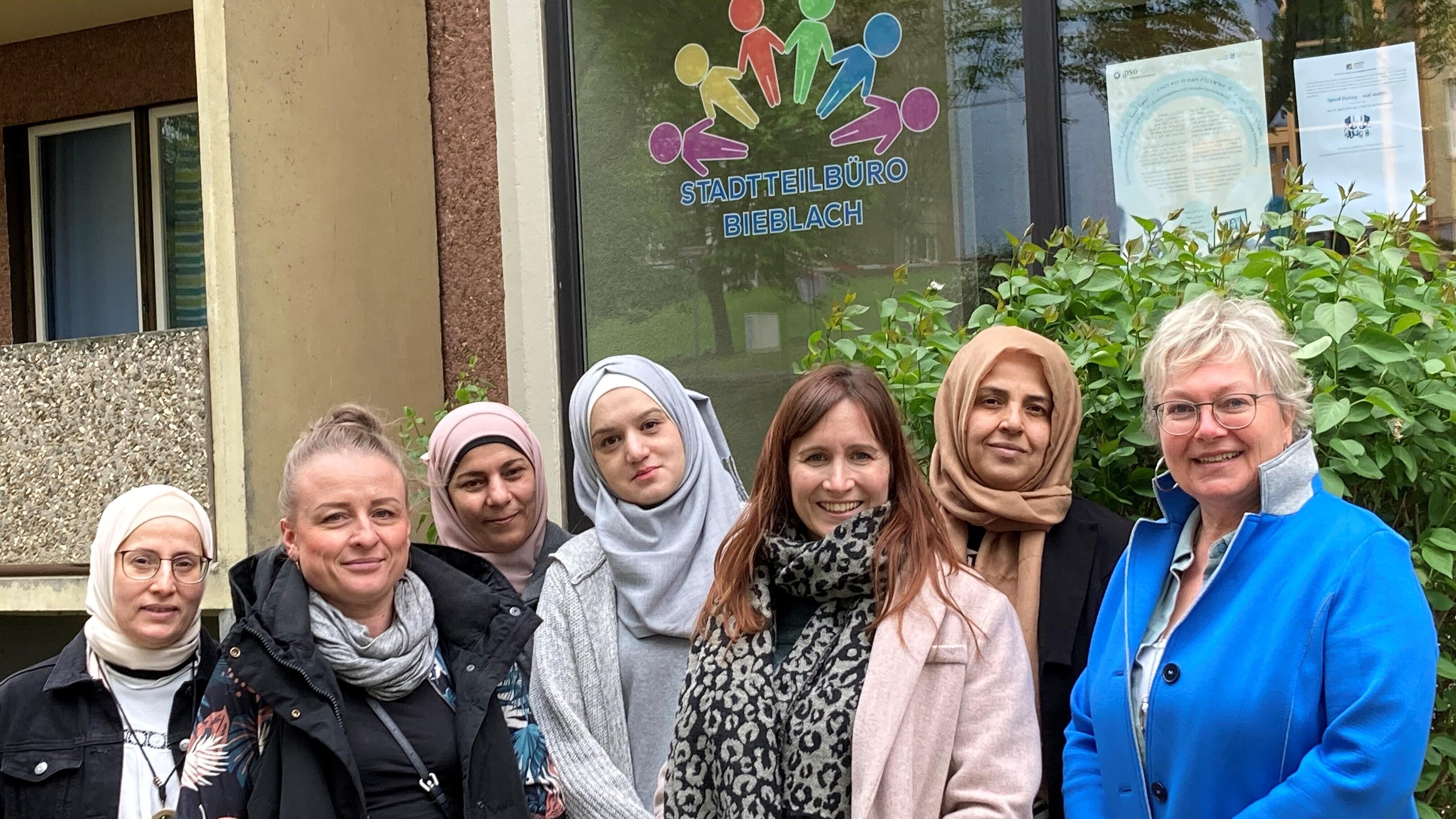 Vor dem Haus des Stadtteilbüros stehen vor einem grünen Busch und dem Logo des Stadtteilbüros am Bürofenster die 7 Frauen wie in der Bildunterschrift beschrieben.. © Foto Stadt Gera