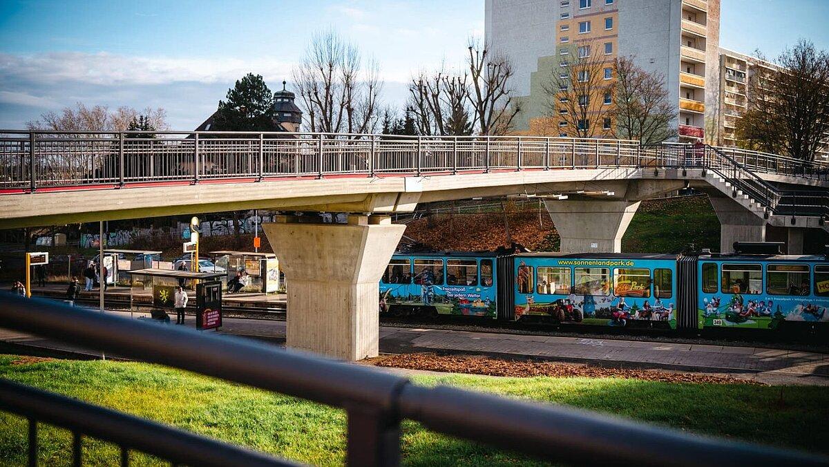 Eine Brücke, unter der eine Straßenbahn durchfährt. © TMDI/ Tony Matysik