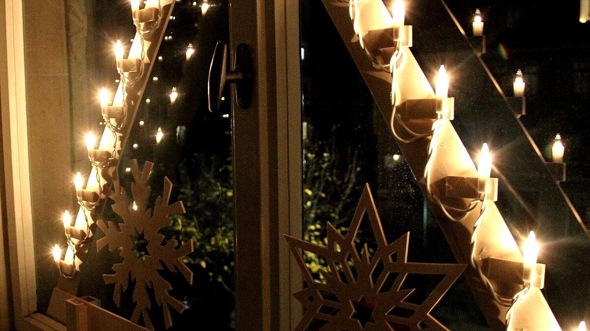 Holzschwibbogen leuchtet am Fenster. © Stadt Gera