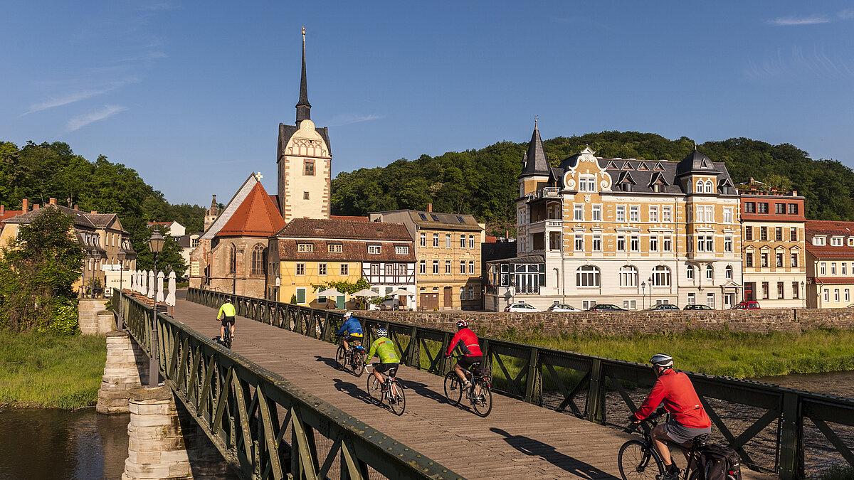 einige Fahrradfahrer auf der Brücke mit Marienkirche im Hintergrund