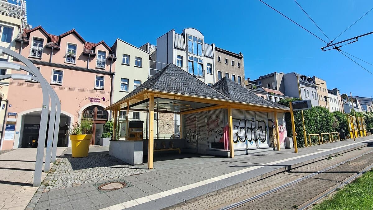 Eine Straßenbahnhaltestelle mit einem kleinen Häuschen, die Fronten sind mit Grafitti beschmiert. © Stadt Gera