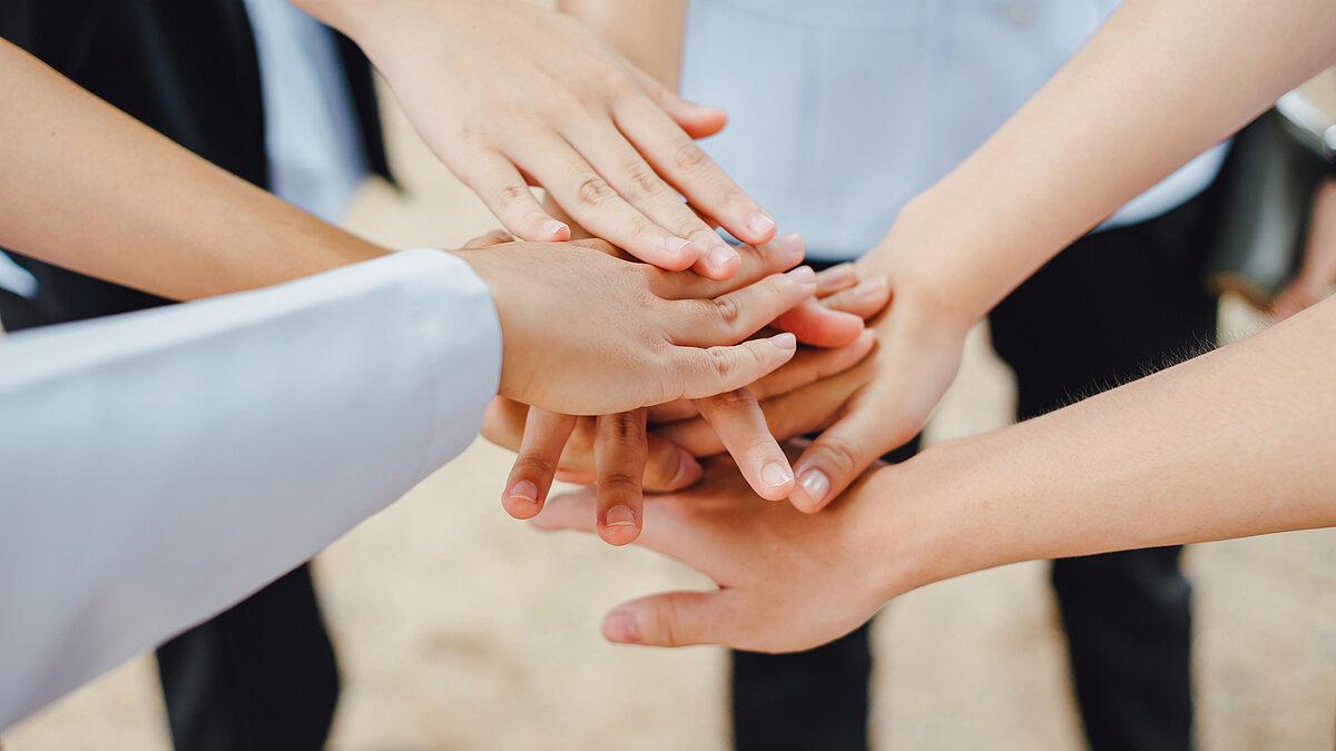 mehrere Hände liegen übereinander. © Adobestock