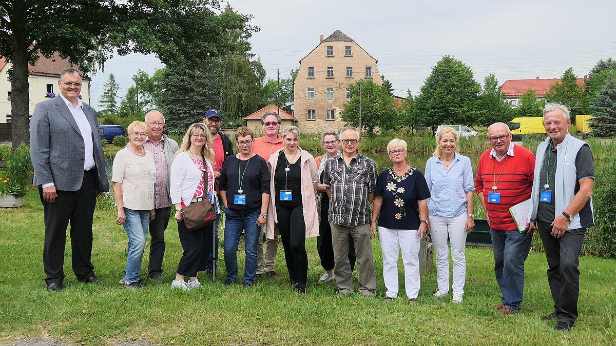 ca. 15 Menschen stehen vor einem Dorfteich. © Stadt Gera