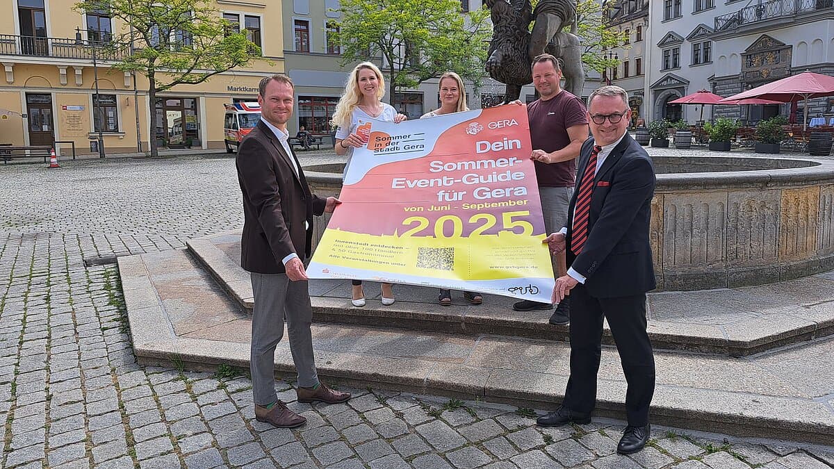 Fünf Menschen vor einem Springbrunnen, die ein großes Plakat halten. © Stadt Gera