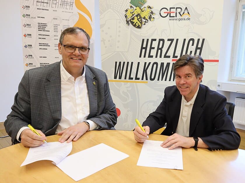 OB und Veranstalter sitzen an einem Tisch und unterschreiben Verträge in Papierform. © Stadt Gera