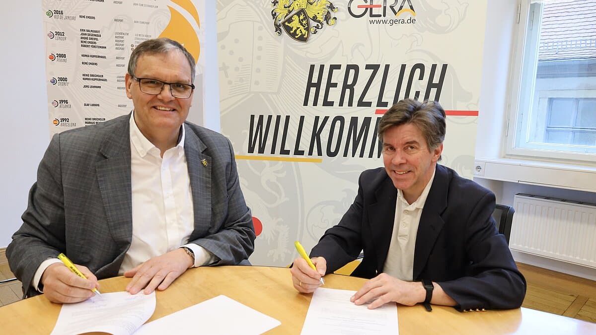 OB und Veranstalter sitzen an einem Tisch und unterschreiben Verträge in Papierform. © Stadt Gera