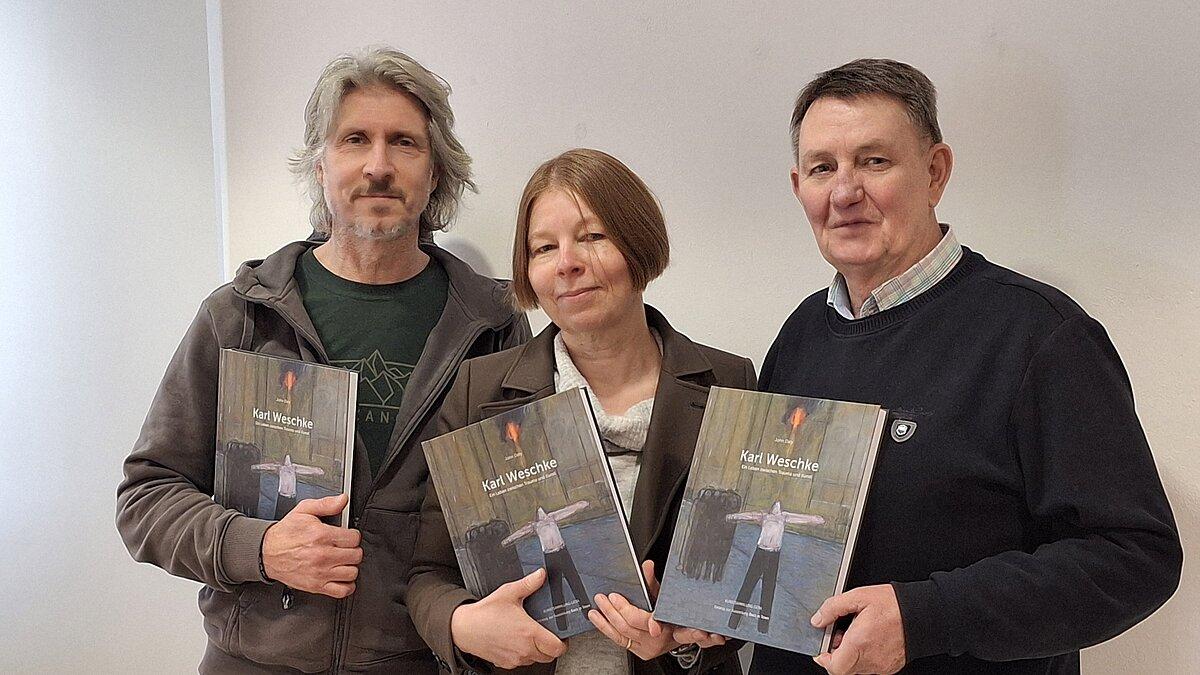 3 Personen stehen nebeneinander und halten den Katalog in den Händen. © Stadt Gera