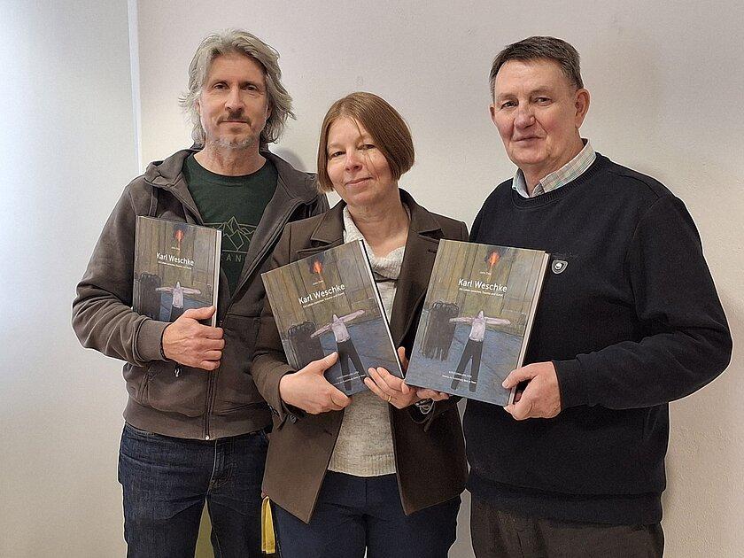 3 Personen stehen nebeneinander und halten den Katalog in den Händen. © Stadt Gera