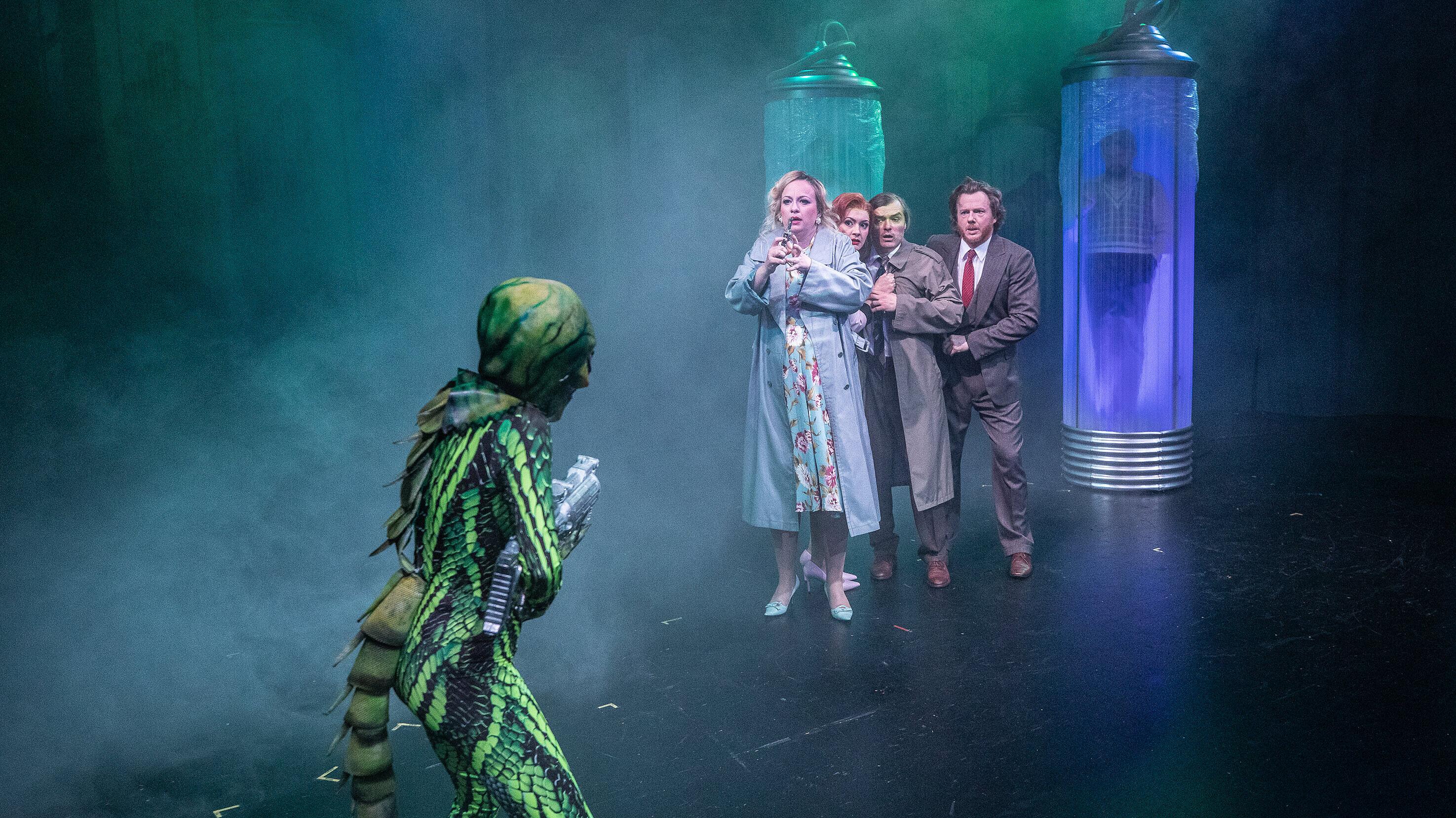 Eine Gruppe von Schaustellern wird während einer Vorstellung von einem Alien mit Waffe bedroht. © Theater Altenburg