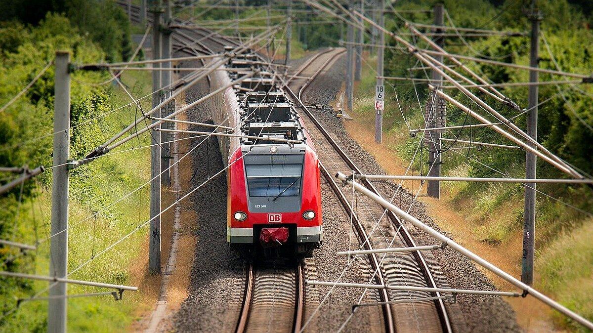 Ein roter Regionalexpress fährt auf einem von zwei Gleisen. © Pixabay
