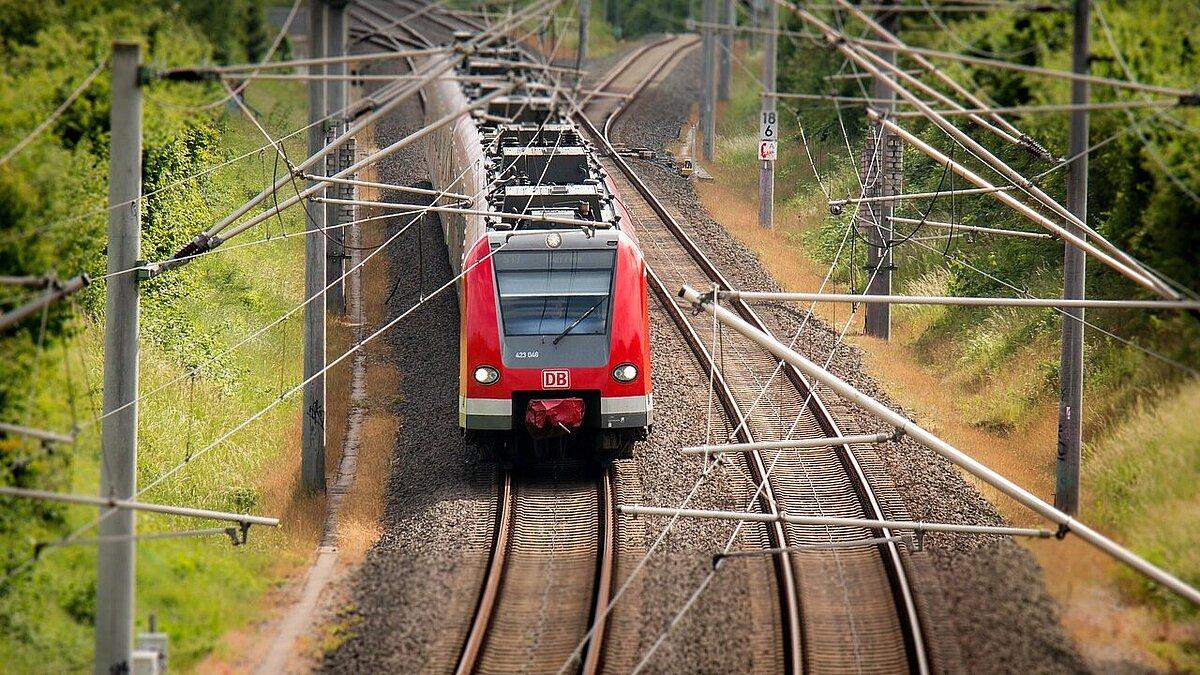 Ein roter Regionalexpress fährt auf einem von zwei Gleisen. © Pixabay