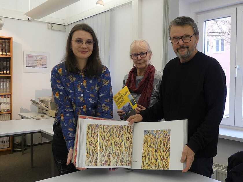 Christel Gäbler (Leiterin des Stadtarchivs Gera) mit Barbara Toch und Wolfgang Schwarzentrub bei der Übergabe des „Werkbuch X. © Stadt Gera