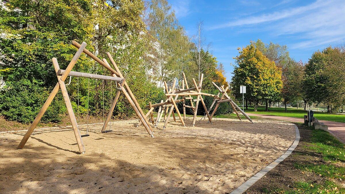 Ein Spielplatz mit Kletterturm und Schaukel aus diversen Holzbalken. © Stadt Gera