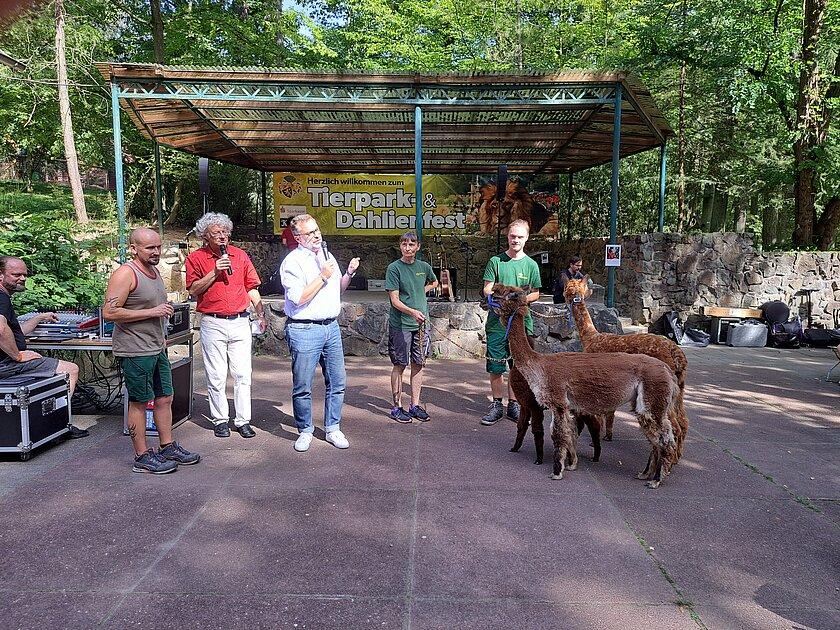 Oberbürgermeister Julian Vonarb mit mehreren Mitarbeitern des Tierparks sowie zwei Alpakas