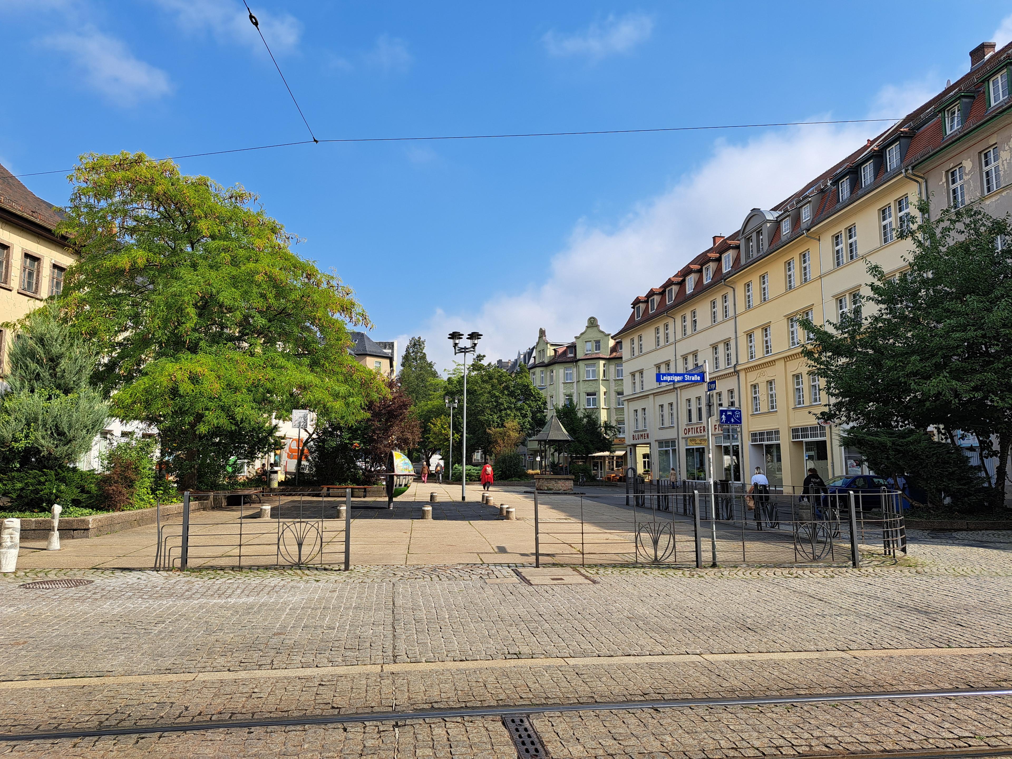 Blick auf einen Platz mit Bänken, einem Spielelement und Grün. © Stadt Gera